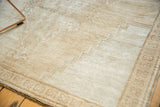Pale coffee brown distressed Oushak rug with geometric stepped corner spandrel.