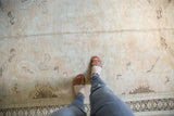 Distressed Oushak rug with faded geometric Caucasian patterns and a prominent rams horn border.