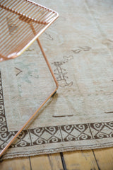 Distressed vintage Oushak carpet with dark chocolate rams horn border and faint foundation showing.
