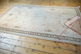 Deep coffee brown geometric rams horn border on a vintage distressed Oushak rug.