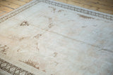 Distressed vintage Oushak rug surface with even wear, geometric motifs, and rams horn border.
