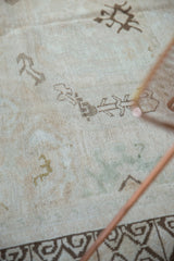 Distressed Oushak rug texture with geometric motifs and uniform pile wear.