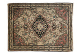 Antique Farahan Sarouk rug, scalloped charcoal medallion, blush and green floral vinery on ivory field.