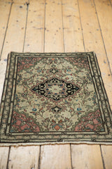 Antique Farahan Sarouk rug's bottom corner with short ivory fringe and blush vinery pattern.