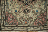 Corner of an antique Farahan Sarouk rug, with delicate blush, sky blue vinery, and border fringe.