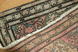 Curled edge of Farahan Sarouk rug, showing low pile and muted floral vinery.