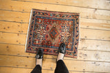 Vintage Karaja rug corner detail, showing geometric pinwheels in brick red and sky blue.