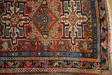 Karaja rug corner, intricate geometric pinwheels, brick red field, dark blue border, low pile.