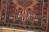 Vintage Karaja rug detail: intricate geometric pinwheels, brick red field, low pile, white fringe.