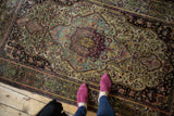 Finely woven central medallion of the antique silk Kashan rug, in rich aubergine and powder blue.