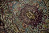Finely woven antique silk Kashan rug, highlighting aubergine medallion and vibrant floral motifs.