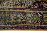 Antique Mohtashem Kashan border detail with aubergine, gold, and emerald silk floral motifs.