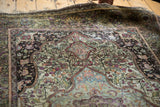 Antique Mohtashem Kashan border with etched black ground and vivid floral motifs.