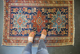 Antique Heriz rug: triple Karaja medallions, serrated flowers, pawn motif in navy, wine red.