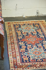 Antique Heriz rug's geometric Karaja motif, serrated flowers, and pawn border.