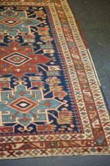 Antique Heriz rug: navy, wine red, and sky blue Karaja motifs with serrated designs and white knots.