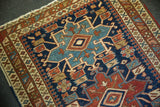 Hand-knotted texture and geometric Karaja motifs on antique Heriz rug's navy field.