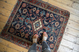 Antique Heriz hand-knotted rug showing diamond medallion, floral palmettes in navy, red, and ivory.