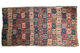 Antique Persian Kilim carpet featuring geometric crab motifs in madder red, blue, ivory, brown.