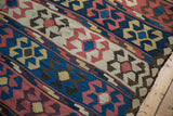 Tattered edge detail on an antique Persian Kilim, featuring madder red and blue crab motifs.