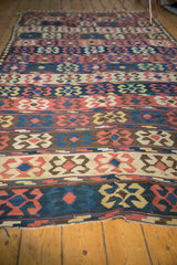 Hand woven Persian Kilim with madder red crab designs and visibly tattered end.