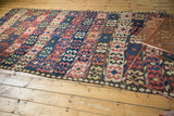 Tattered end of antique Persian Kilim, geometric crab designs in red, blue, ivory.