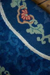 Hand-knotted Art Deco rug's edge: cobalt blue, pale green floral vines, slight tatter.