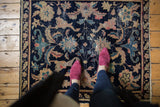 Detail of antique Chinese rug, navy ground with Persian palmettes, vinery, and light pile wear.