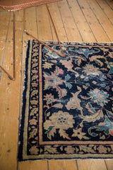 Antique Chinese rug with a worn navy field, faded stylized palmettes, and side tatter.