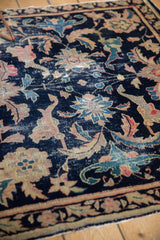 Detail of antique Chinese rug, navy field with palmettes, lotus flowers, and visible foundation.