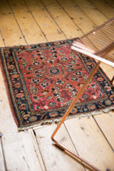 Angled vintage Persian Sarouk rug with raspberry floral vinery, low pile, tattered ends.