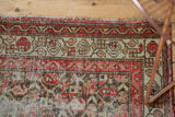 Worn red, charcoal brown, and ivory floral trellis with wide border on a Hamadan rug.