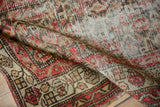 Antique Hamadan rug's wide border with red, brown, ivory floral vines and even pile wear.