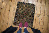 Vintage Farahan Sarouk rug's upper left corner, with navy border and floral trellis.