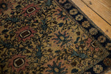Vintage Farahan Sarouk rug corner, navy border and antique ivory field with blush trellis motifs.