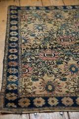 Vintage Farahan Sarouk rug corner with navy border and blush, ivory trellis pattern.