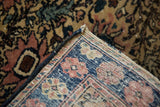 Dog-eared corner of Farahan Sarouk rug, showing hand-knotted backing and secure dark blue edge.
