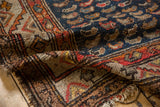 Antique Persian Hamadan rug detail showcasing hand-knotted Mahi Mahi motif, worn pile, and tattered ends.