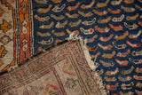 Close-up of antique Hamadan rug with navy Mahi Mahi pattern, hand-knotted foundation, and aged edge.