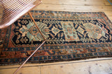 Navy, rust, ivory, and sky blue floral cross sections and border on a Vintage Hamadan rug.