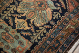 Vintage Hamadan rug showcasing low pile and ornate border with navy, rust, and sky blue patterns.