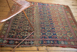 Antique West Persian rug's central wear with exposed foundation amidst floral panel medallions.