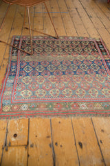 Antique West Persian rug's tattered fringe, madder root red, sky blue, and green borders.