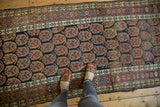 Close-up of antique Northwest Persian runner, revealing alternating boteh pattern and time-softened charcoal, copper, and blue hues.