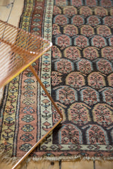 Antique Persian runner with time-softened germinating plant boteh motifs and patterned border.
