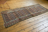 Detail of the antique Northwest Persian runner's distinct multi-banded border designs.