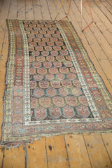 Antique Northwest Persian runner's corner, showing frayed end and botanical boteh motif.
