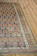 Antique Persian runner's frayed fringe, intricate border with copper, sky blue tones.