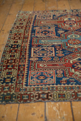 Antique Caucasian rug detail: geometric motifs in navy, madder red, saffron, showing aged wear to pile.
