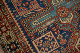 Hand-knotted Antique Caucasian rug: geometric patterns, navy, madder red, saffron, visible foundation.